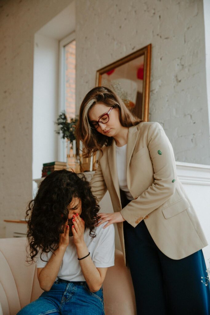 Einfühlsame Coaching Sitzung mit einer Coachin die ihre Klientin tröstet